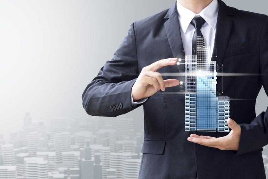 Profissional segurando a maquete de um edifício, representando a gestão condominial